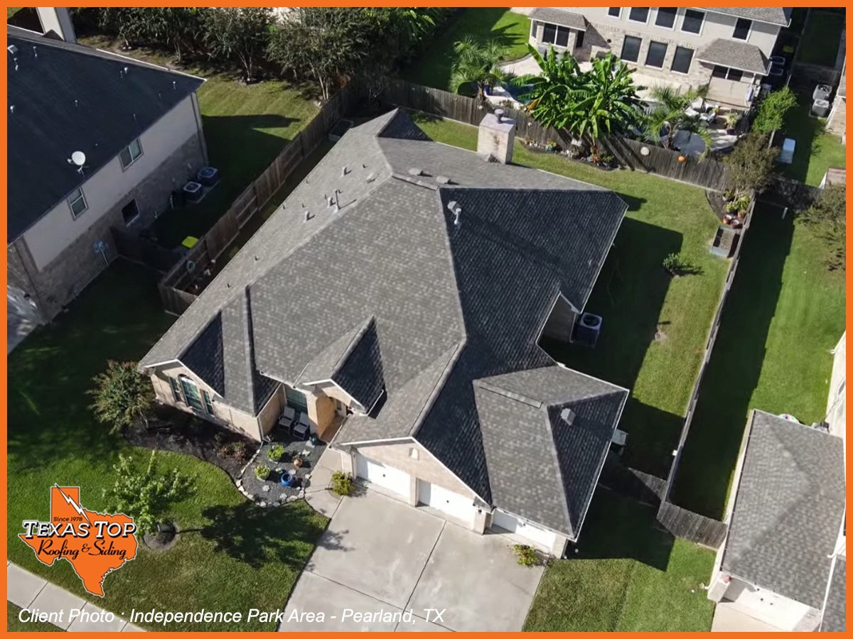 Aerial view of residential house with gray multi-pitched roof