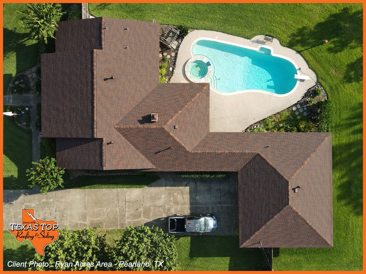 Aerial view of residential home with brown roof and swimming pool